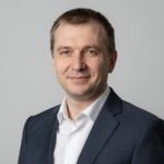 Портрет уверенного российского бизнесмена с дружелюбным взглядом на размытом нейтральном фоне в студии